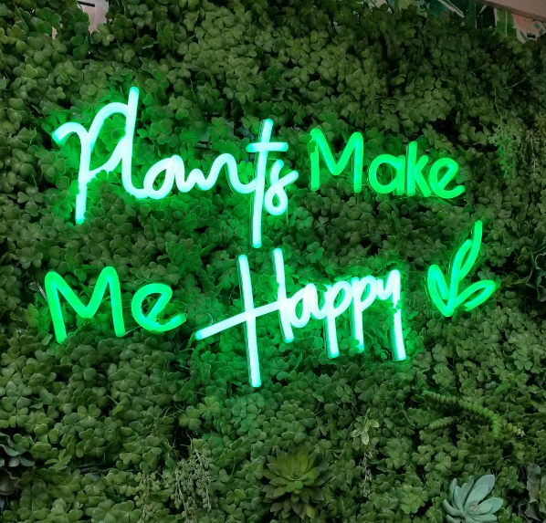 green neon sign that says &quot;plants make me happy&quot;