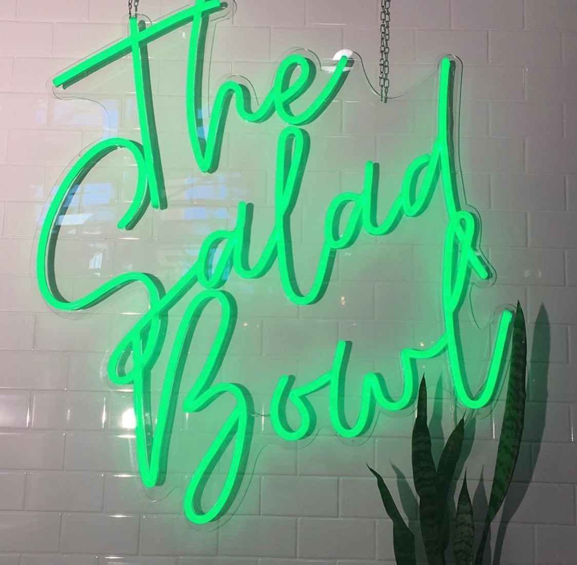 green neon sign that says &quot;The salad bowl&quot;